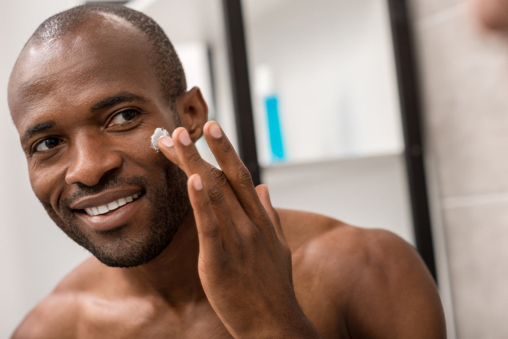 man applying facial lotion