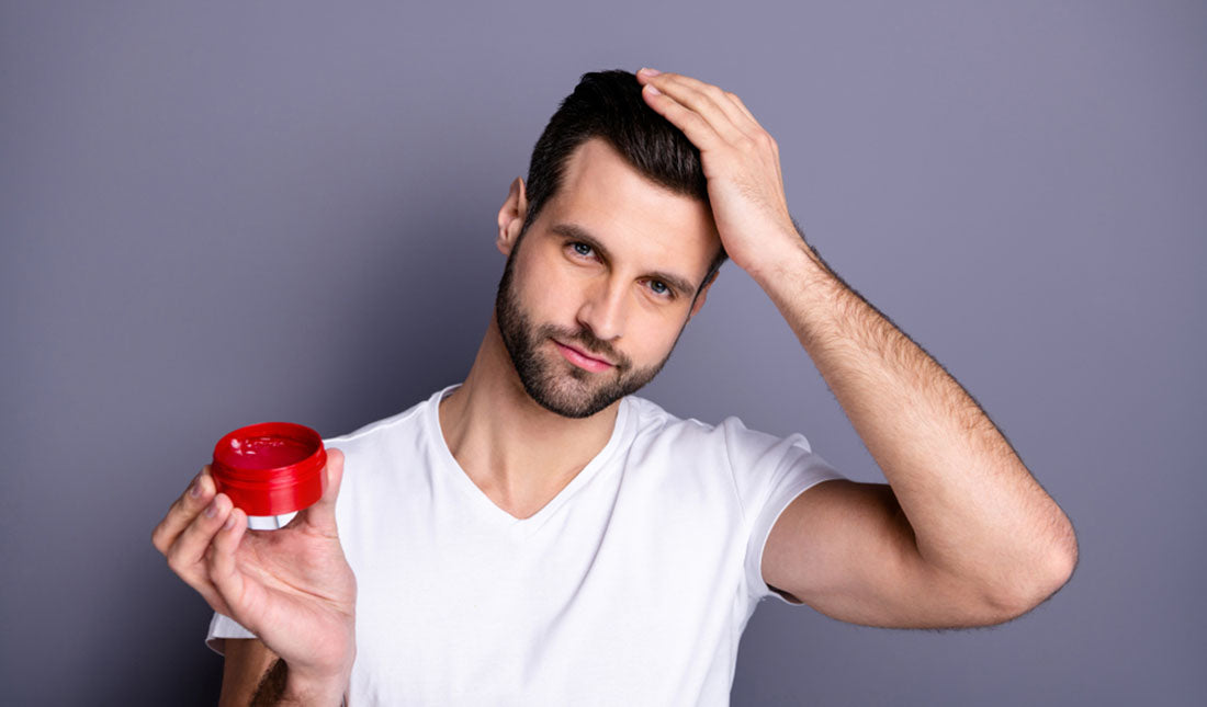 man applying pomade to hair