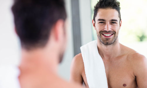 man looking through bathroom mirror