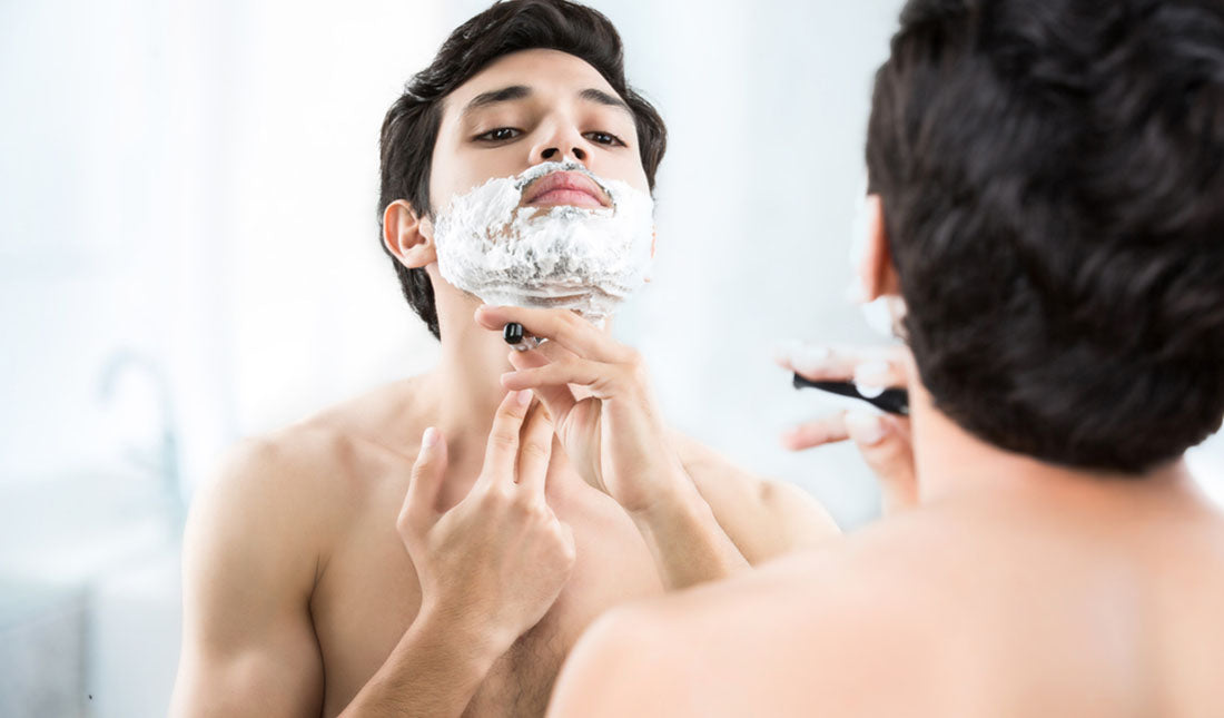 man shaving in bathroom