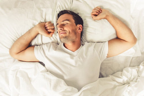 man stretching in bed