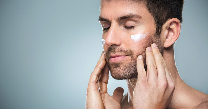 man using cream under eyes