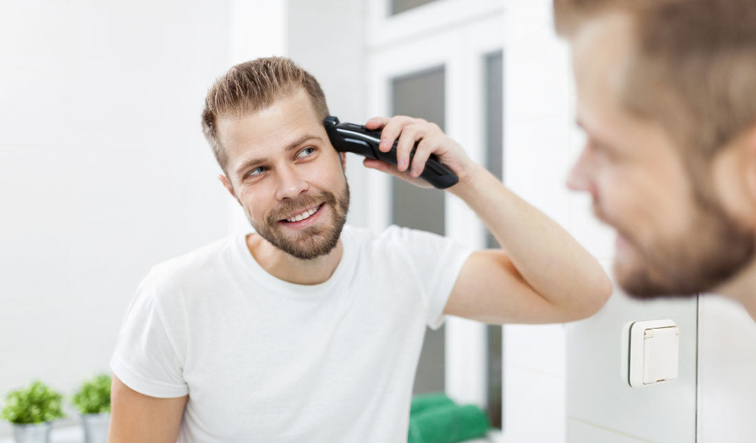 man using hair clippers