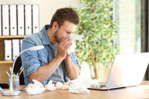 man with cold at desk