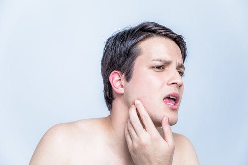 young man checking his face